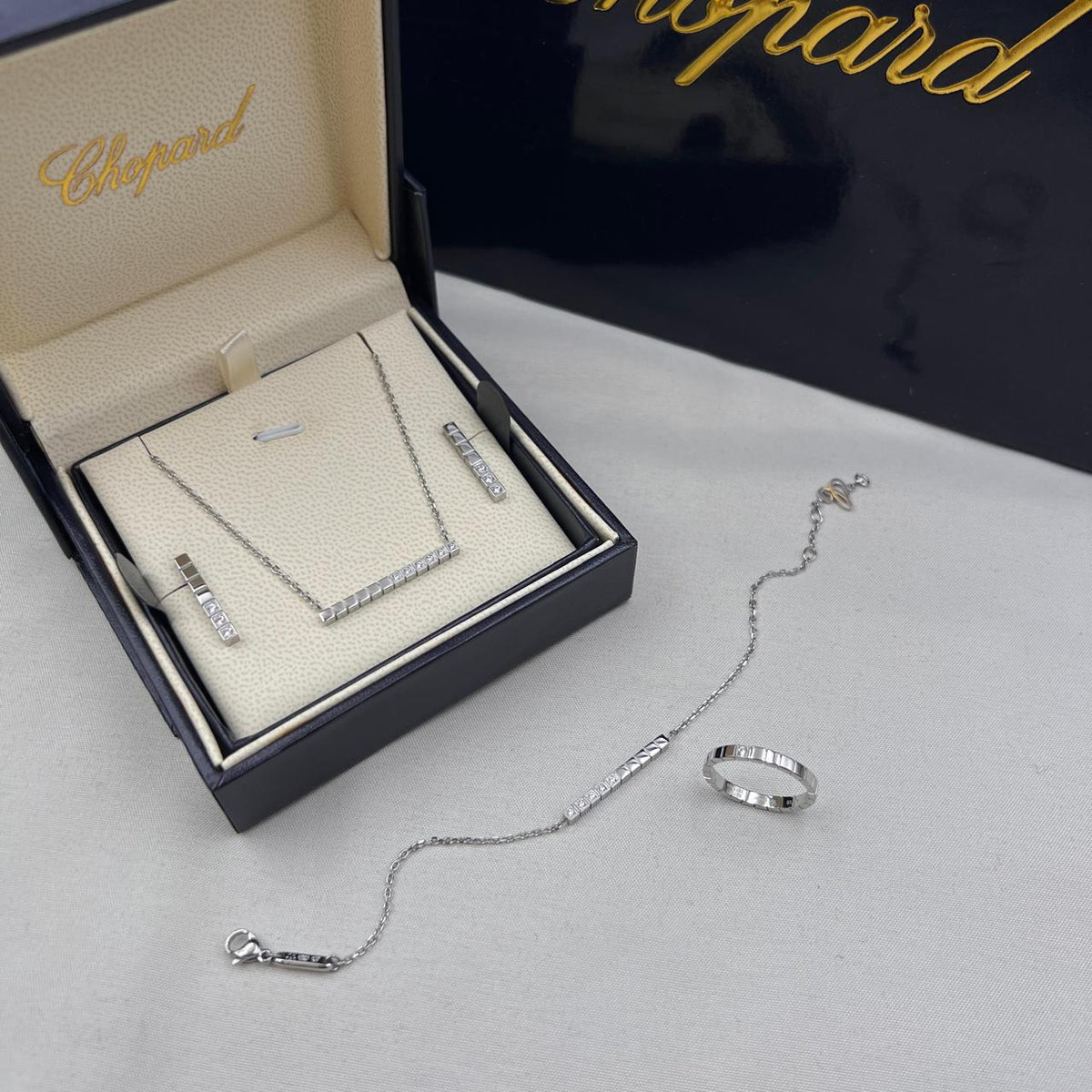 Chopard Ice Cube-Inspired Four-Piece Jewelry Set — -Tone Bar Pendant Necklace, Matching Stud Earrings, Chain Bracelet & Band Ring with Geometric Cube Detailing and Sparkling Stone Accents.