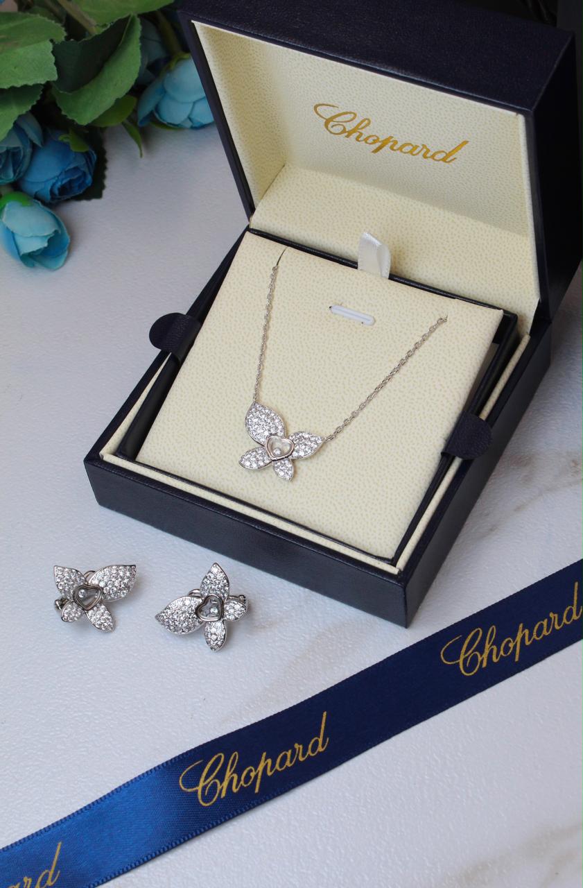 Chopard Happy Diamonds Butterfly Necklace & Earrings Set — White-Tone Metal with Pavé-Set Stones and Heart-Shaped Floating Diamond Details.