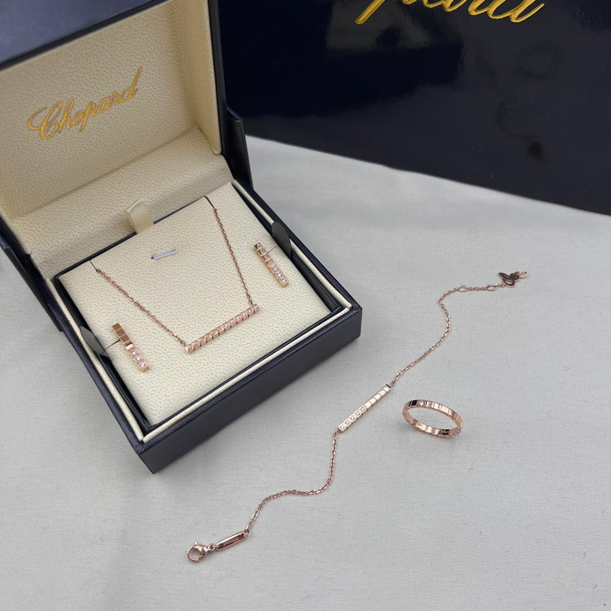 Chopard Ice Cube-Inspired Four-Piece Jewelry Set — -Tone Bar Pendant Necklace, Matching Stud Earrings, Chain Bracelet & Band Ring with Geometric Cube Detailing and Sparkling Stone Accents.